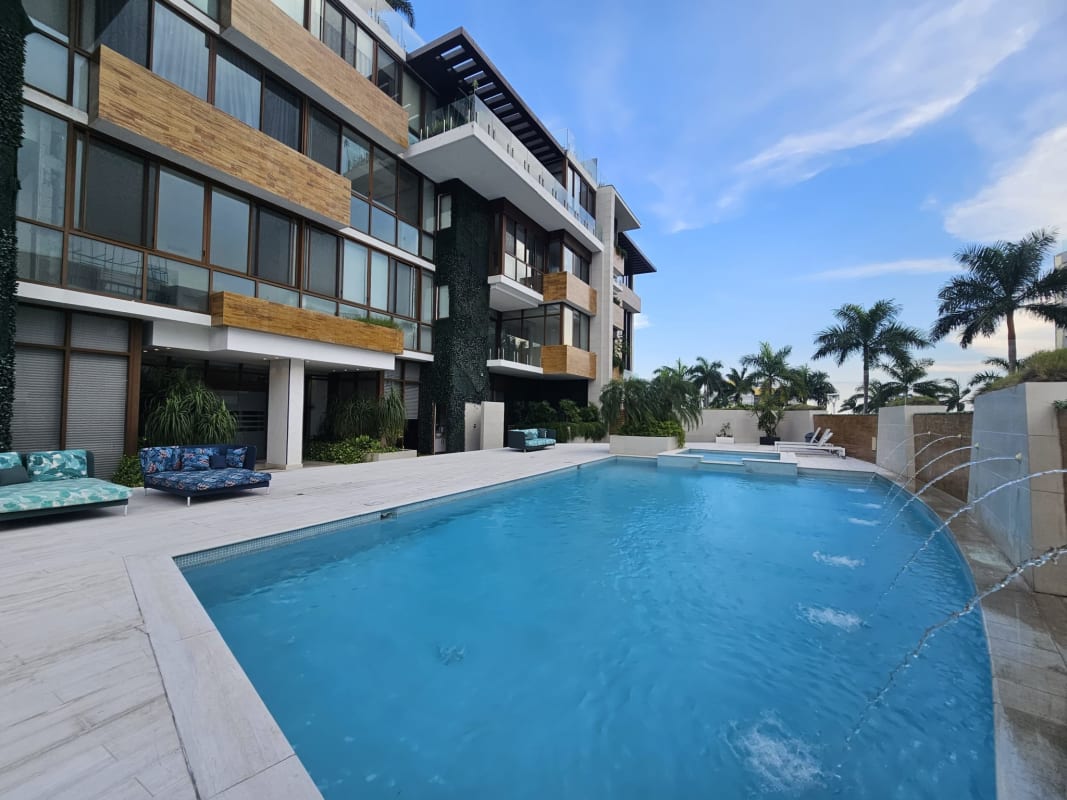Modern outdoor pool with palm trees and lounge chairs PH Garden Apartments Ocean Reef Panama City