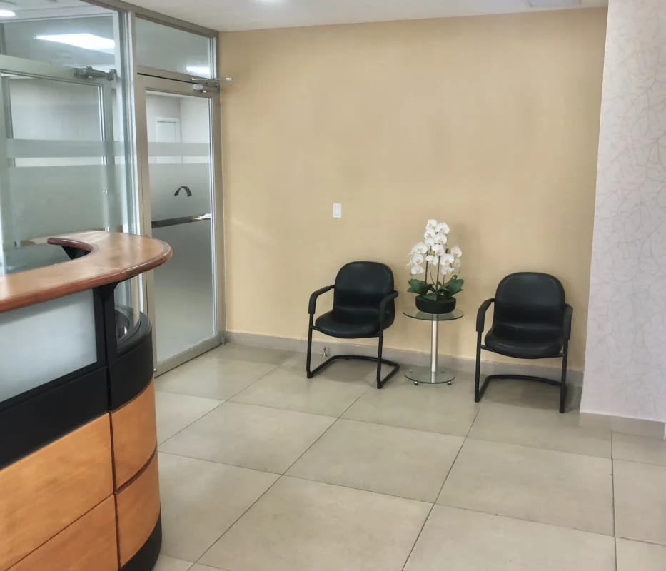 Modern reception with curved desk, glass doors, black chairs in office space Punta Paitilla Panama City