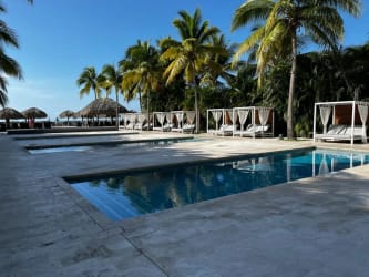 Resort swimming pool with palm trees, cabanas in Buenaventura Panama