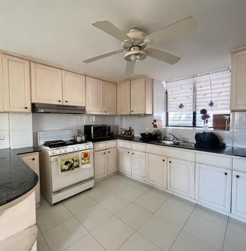 Kitchen with granite counters white cabinets ceiling fan large window Villa de las Fuentes
