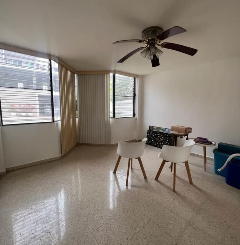 Living area large windows city views ceiling fan neutral tones Villa de las Fuentes