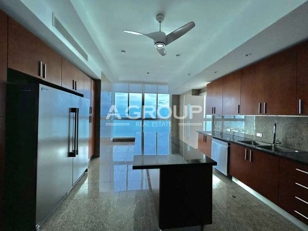 Spacious gourmet kitchen granite countertops large fridge floor-to-ceiling windows ocean view