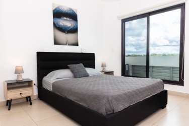 Spacious bedroom with ocean view sliding glass doors at PH Las Olas Vista Mar