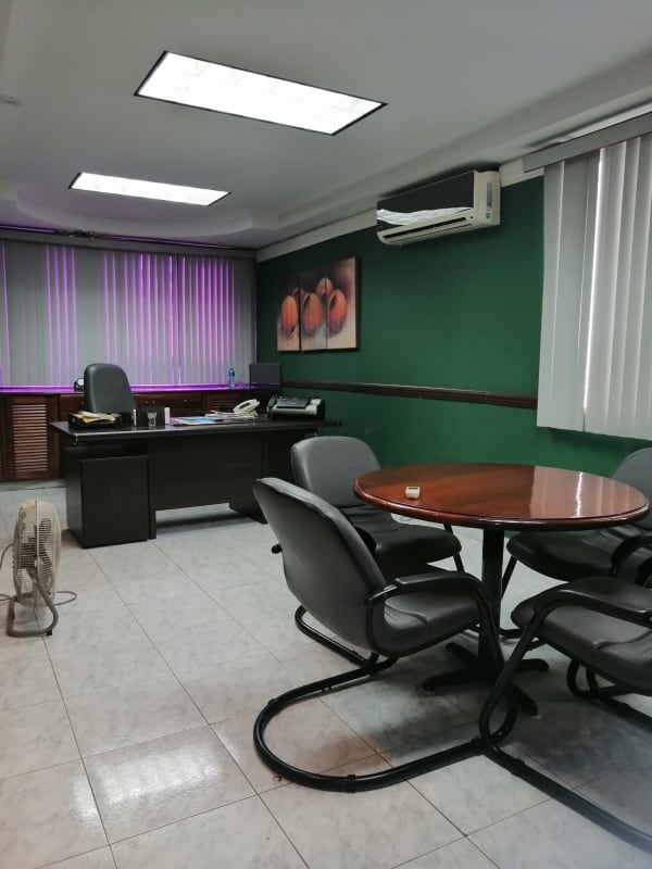 Meeting room space with green walls, office chairs, tile flooring Obarrio