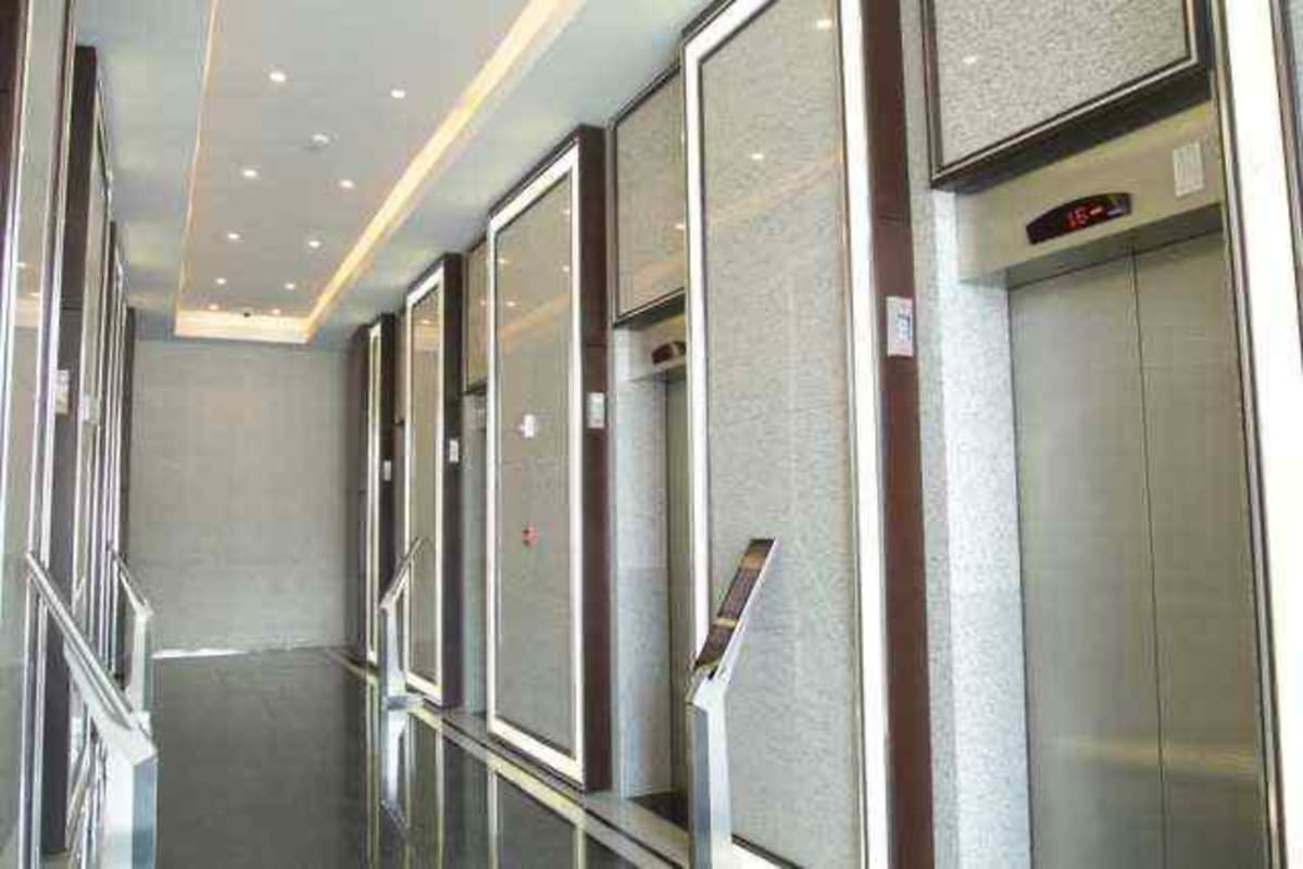 Modern elevator lobby with multiple elevators and mirror wall panels in PH Golden Point Tower Panama