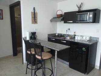 Modern kitchenette with granite countertop black cabinetry bar stools PH Ibiza Playa Coronado Panama