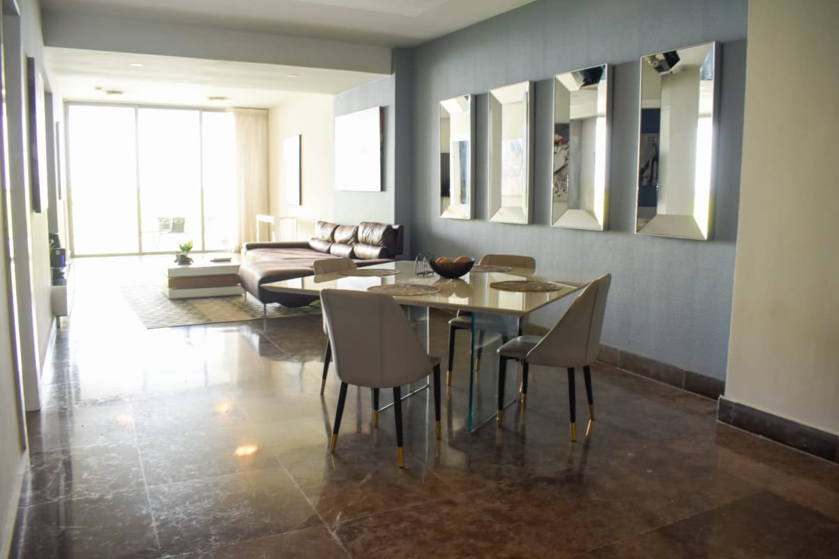 Open concept luxury furnished living room and dining area with balcony at Yoo Panama on Avenida Balboa