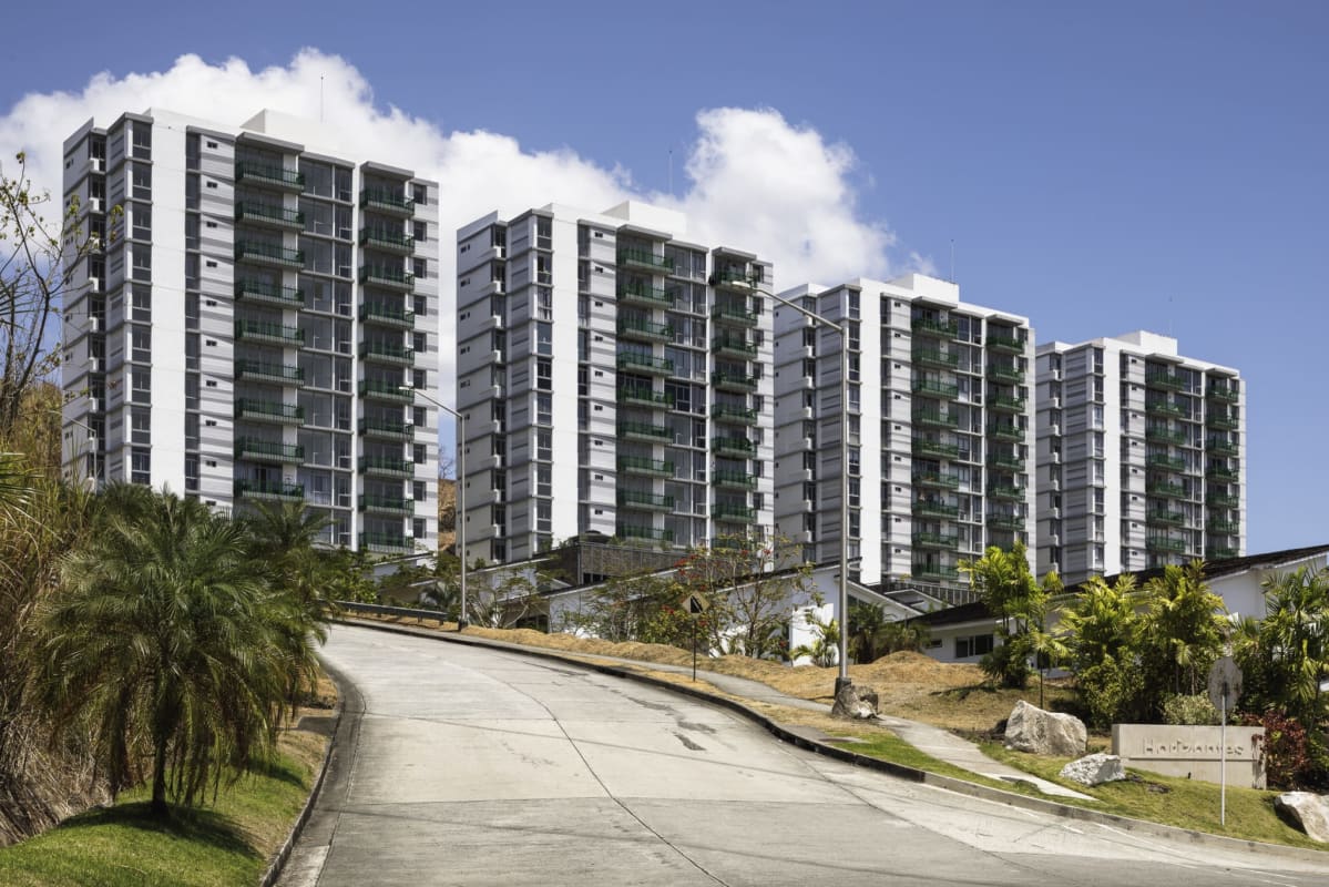 Multiple tall condominium towers with glass balconies and landscaped entrance at PH 4H Panama