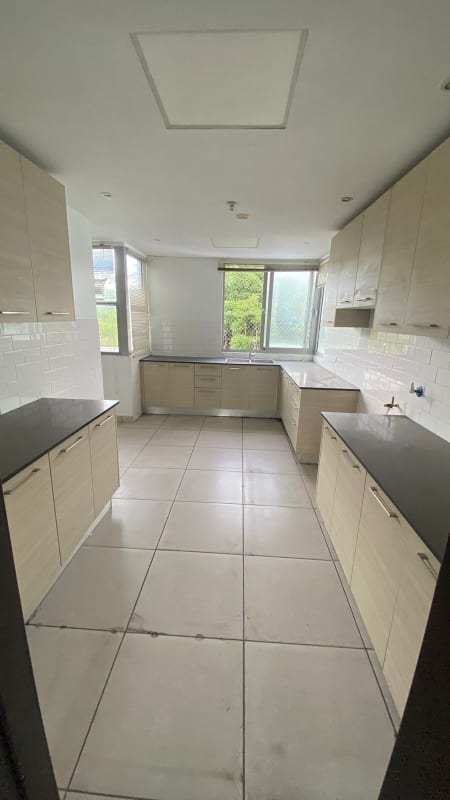 Minimalist kitchen with large windows, beige cabinets, black granite countertop in PH 4H Panama