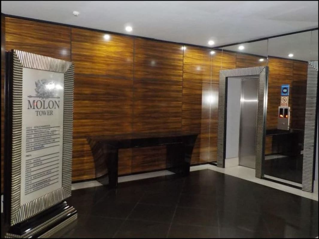 Modern lobby with directory sign, wood paneling and elevator in PH Molon Tower Panama City