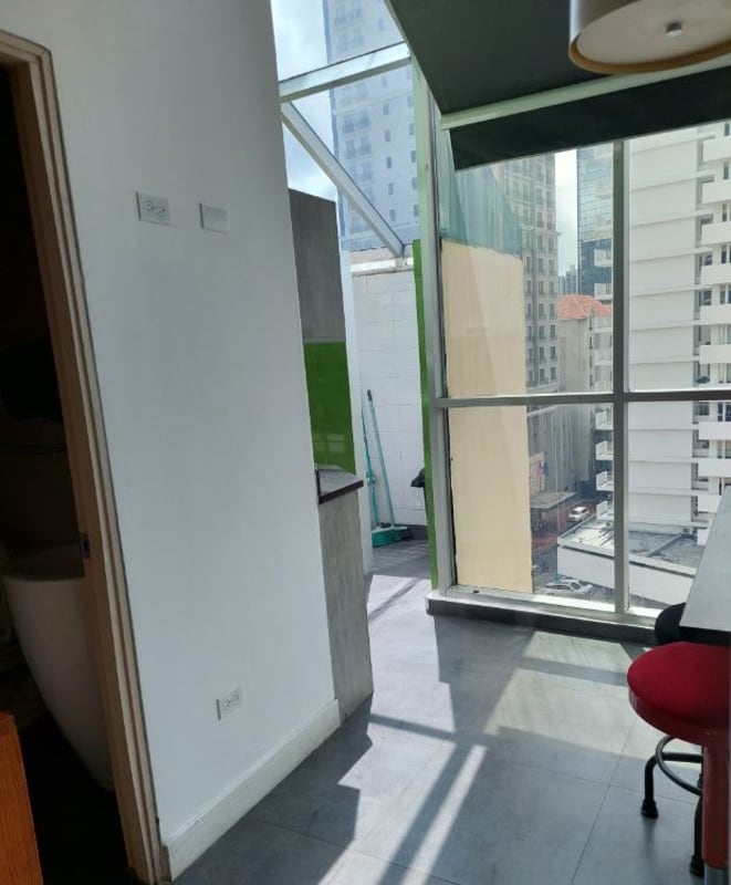 Kitchenette and seating with floor-to-ceiling windows and skyline in PH Molon Tower Panama City