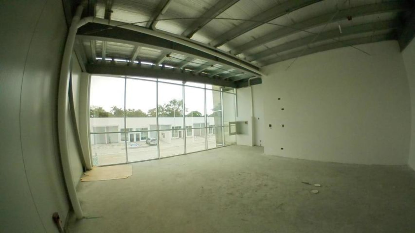 Glass facade commercial warehouse with ACM panel cladding and electric loading gate.