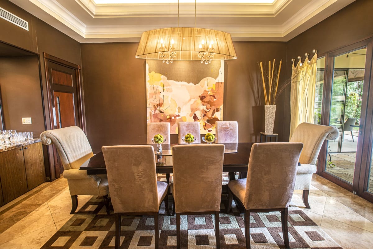 Formal dining room with chandelier, seating for 12, large windows in Balmoral mansion Panama City