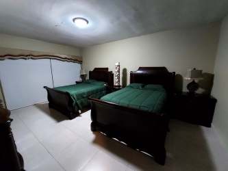 Traditional guest bedroom with double beds and closet at Las Olas tower Vista Mar Panama