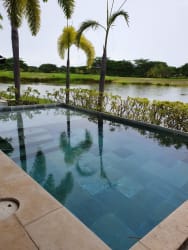 Private swimming pool overlooking palm-lined lagoon in Buenaventura Beach Resort Panama