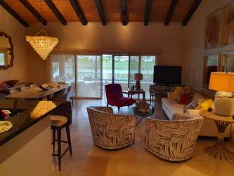 Front view of two-story Mediterranean home with golf course and palm landscaping in Buenaventura Panama