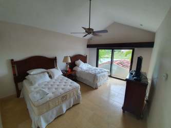 Bedroom with two beds, vaulted ceiling, ceiling fan and balcony access in Buenaventura Resort Panama