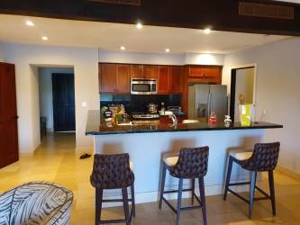 Modern kitchen with granite counters, stainless appliances, breakfast bar in Buenaventura Resort Panama