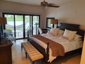 Master bedroom with large sliding doors to terrace overlooking lagoon in Buenaventura Panama