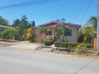 Kitchen with white cabinets, red curtains, and tiled backsplash in Don Esteban Monagrillo house for sale