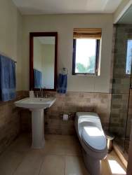 Spacious living-dining room with tile floors and access to private balcony overlooking tropical gardens in Buenaventura Panama