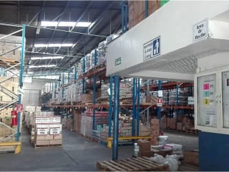 Spacious warehouse interior high shelves pallets industrial lighting David Panama