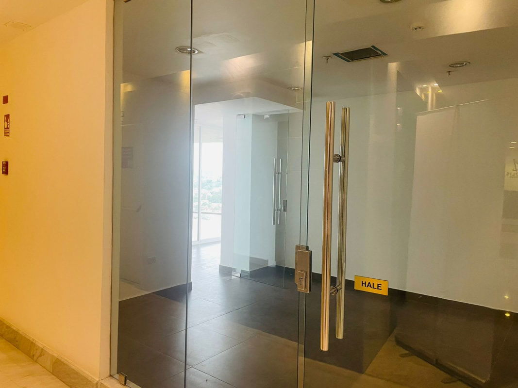 Glass entrance to corporate office unit in PH Aseguradora Ancón Costa del Este Panama high rise tile flooring