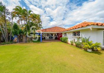 Mediterranean-style villa with red tile roof, large lawn, tropical plants in Punta Barco Panama for sale