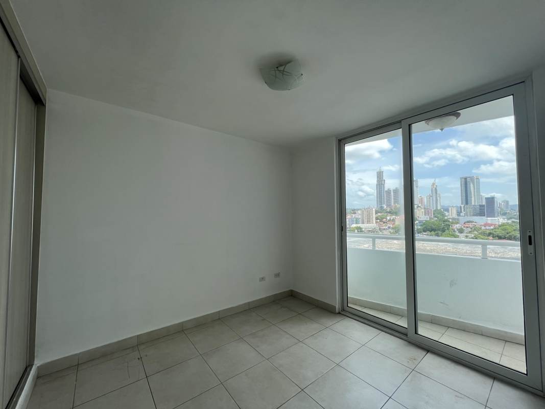 Empty minimalist bedroom with sliding doors to balcony and skyline view PH El Mare Edison Park Panama