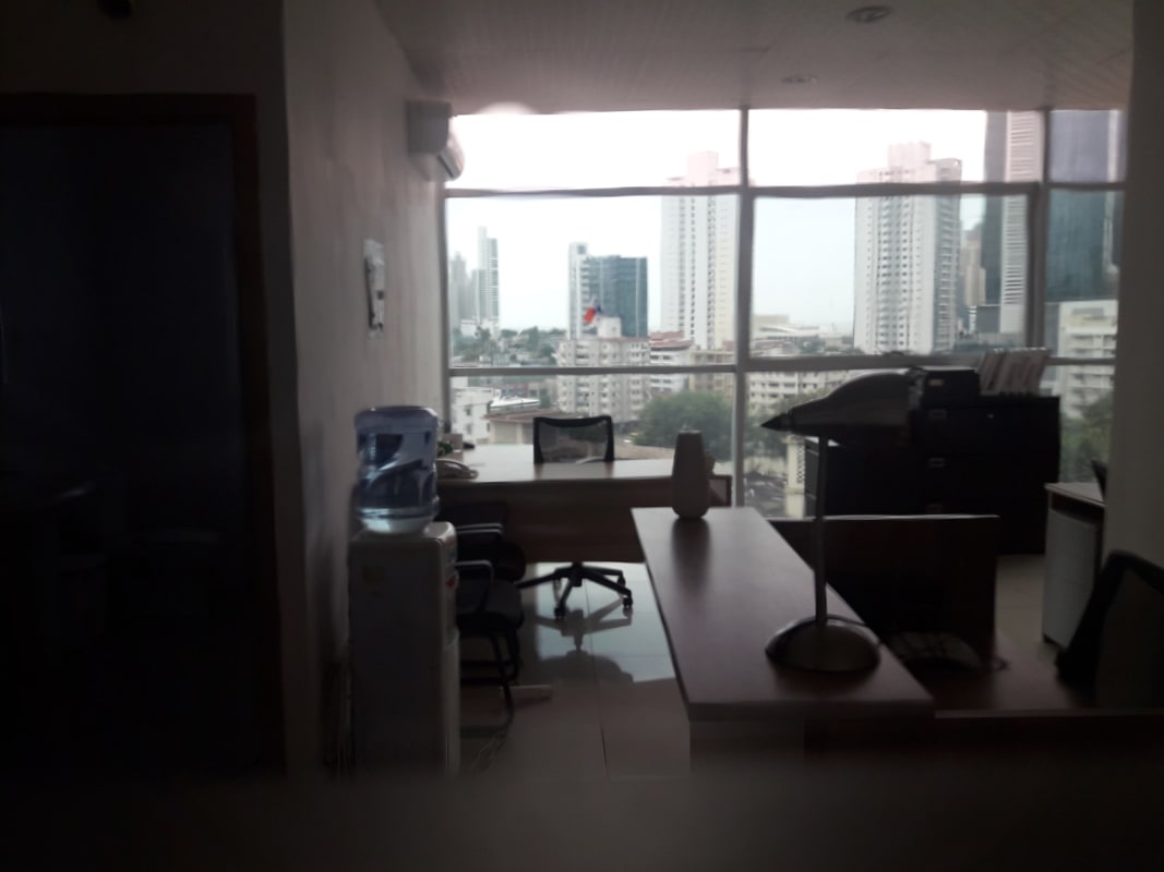 Clean modern office interior with panoramic glass windows facing Panama skyline in Obarrio