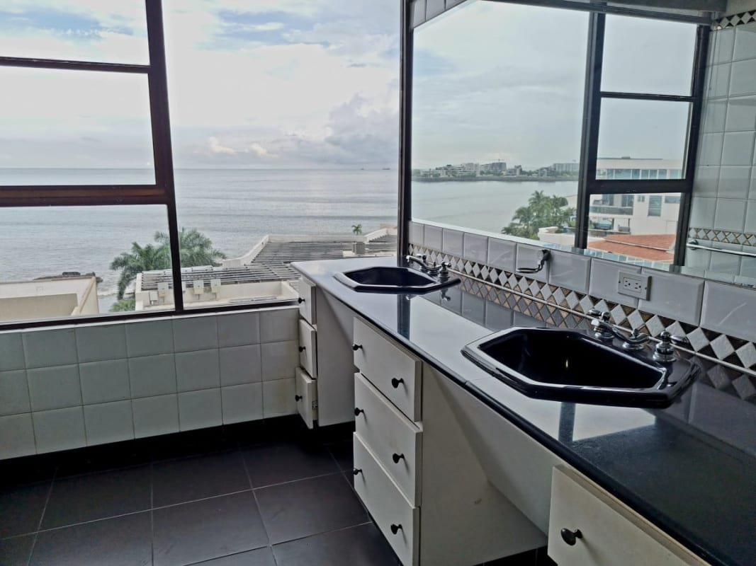Luxury bathroom with double sinks and large ocean-view windows at PH Maresias Punta Paitilla
