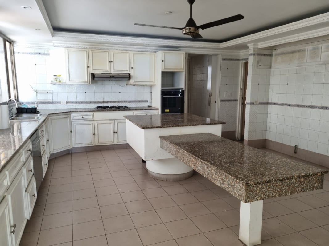 Large kitchen with granite counters, white cabinetry, double islands and ocean views in PH Maresias Punta Paitilla Panama City