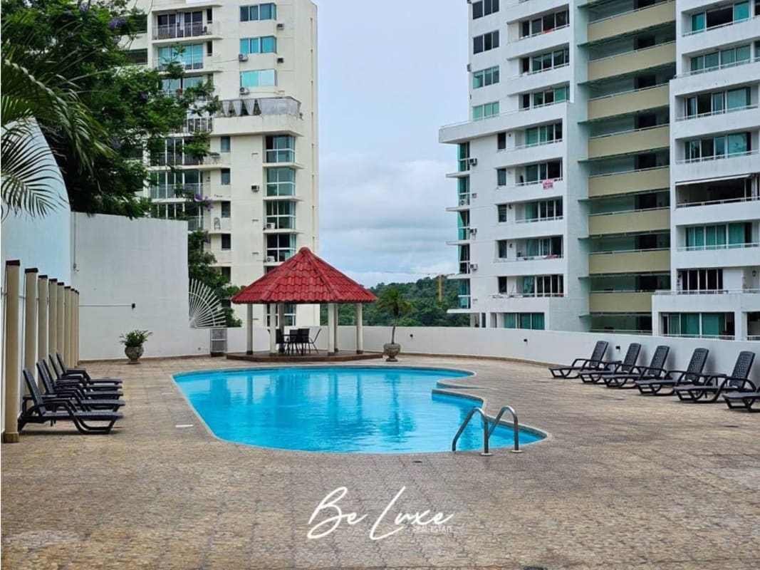 Outdoor community swimming pool area with sun loungers surrounded by high-rise buildings in Edison Park