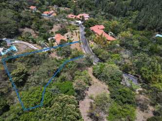 Aerial of wooded mountain land in Altos del María with paved road nearby
