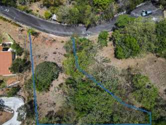 Aerial photo of mountain slope lot outlined amid trees and road access