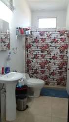 Simple bathroom with shower, window, pedestal sink in country home Cabuya Chame