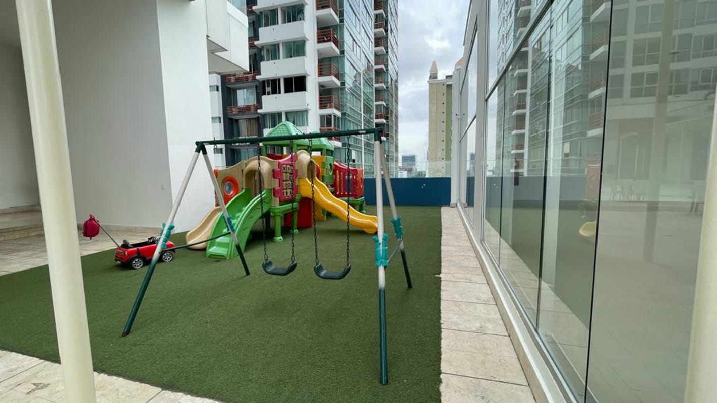 Children's outdoor playground with turf and slides at PH Top Tower Costa del Este