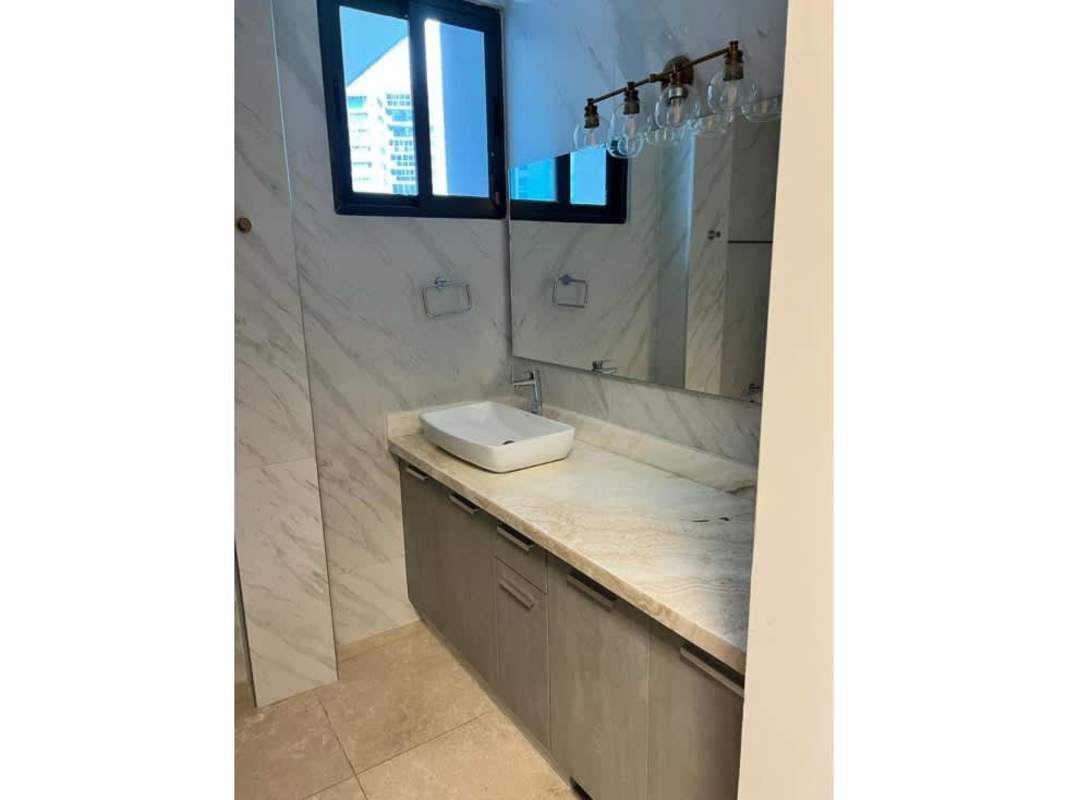 Modern bathroom with marble walls, vessel sink, large mirror in PH Deluxe Residence Punta Paitilla Panama