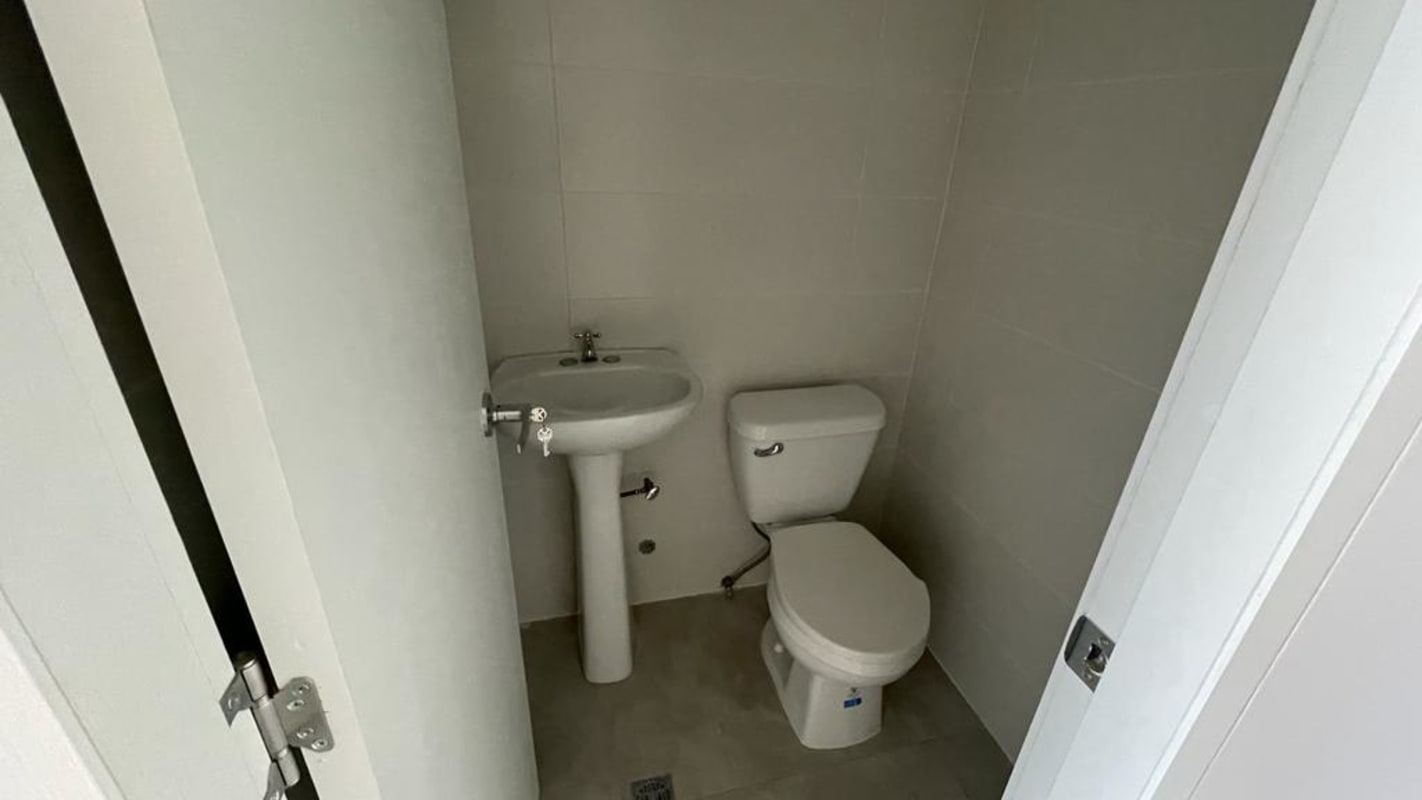 Minimalist bathroom with pedestal sink toilet in medical consult office Torre Arboleda Costa del Este