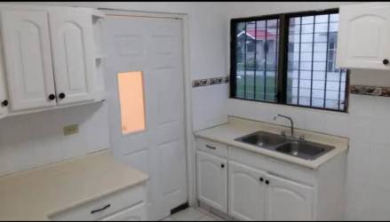 White cabinetry kitchen with tiled countertop in house for rent David Chiriquí