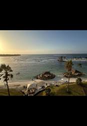 Modern living room with floor-to-ceiling windows, panoramic Caribbean views, open dining, Playa Escondida Panama apartment.