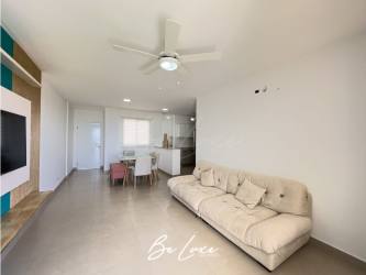 Modern open plan living room with large sofa and balcony access in Playa del Sol condo Panama