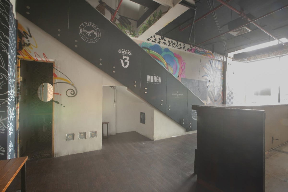 Industrial-style bar interior with murals, staircase, exposed ducts Nova Plaza San Francisco Panama