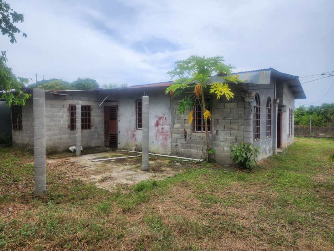Front of unfinished house with balcony area and fenced yard in Pacora Panama