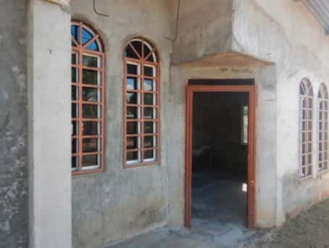 Facade of unfinished affordable house with arched windows in Pacora
