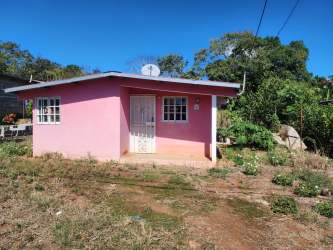 Side exterior of pink house fenced yard satellite dish in El Coco La Chorrera Panama