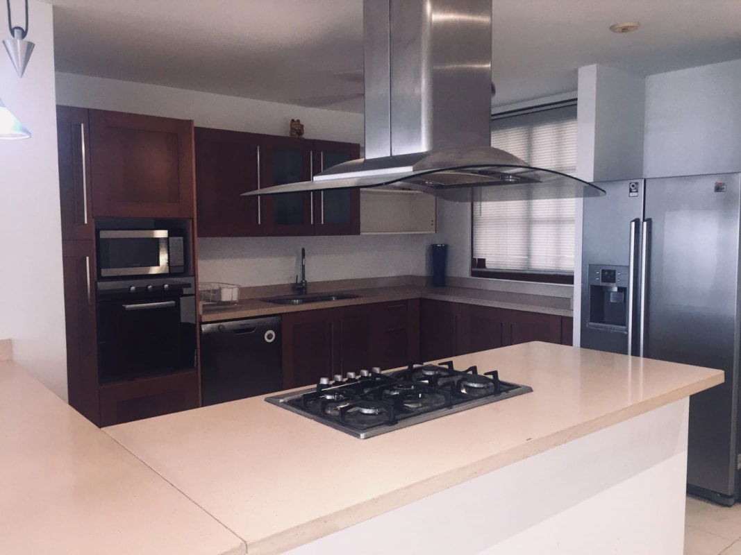 Open living and dining area with staircase inside penthouse at Casa Malecón Panama