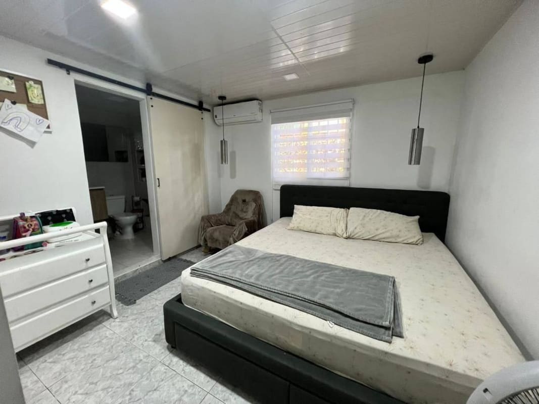 Bedroom with large bed, sliding door to ensuite bath Don Bosco Panama house for sale