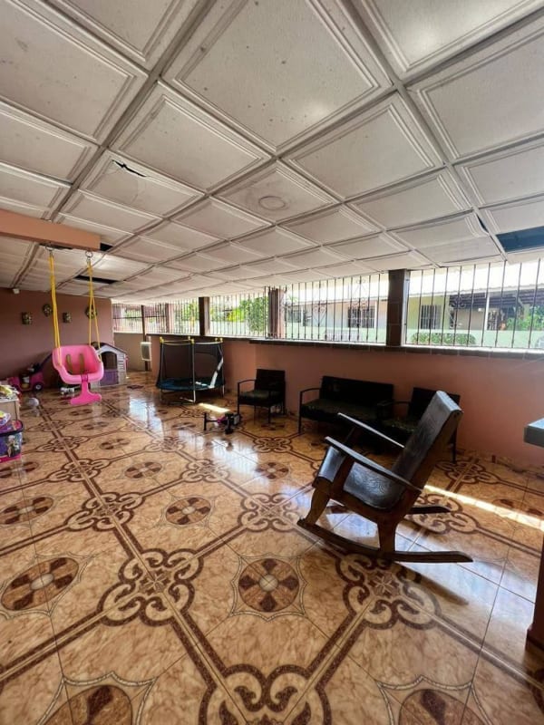 Covered enclosed patio with play space and seating Don Bosco Panama house for sale