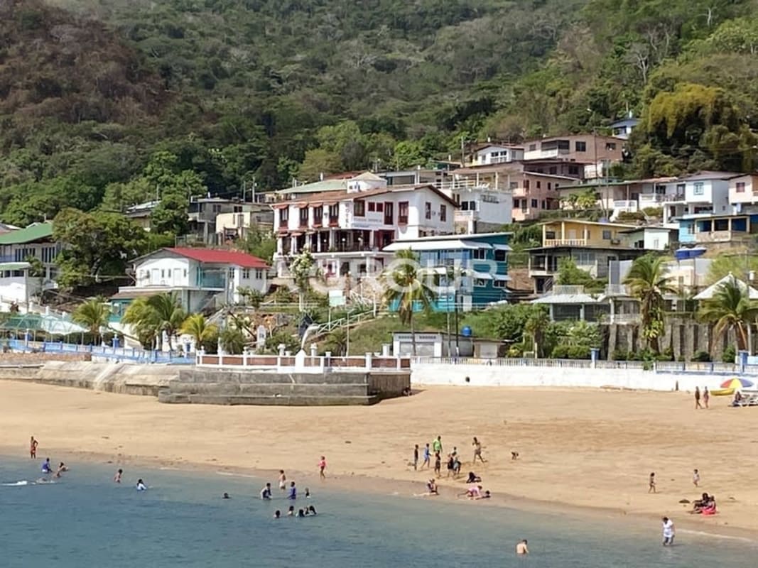 Colorful coastal houses beachfront at Isla Taboga Panama with boats and palm trees